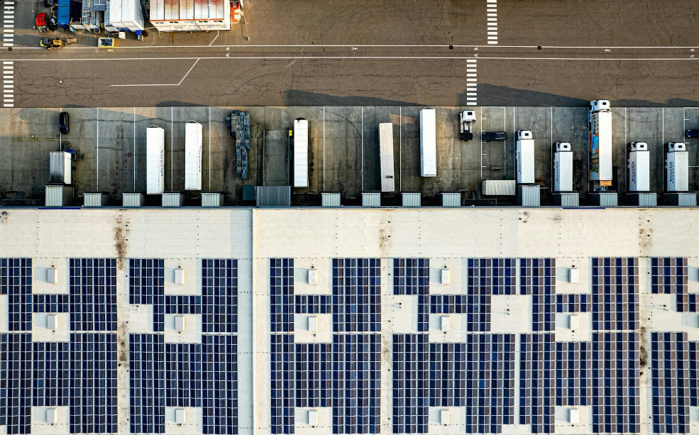 Top-down view of a parking lot with trucks and solar panels.