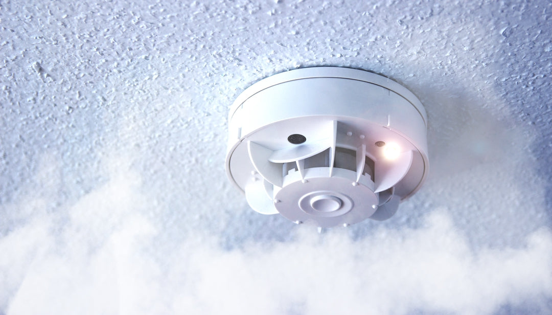White smoke detector on a textured white ceiling